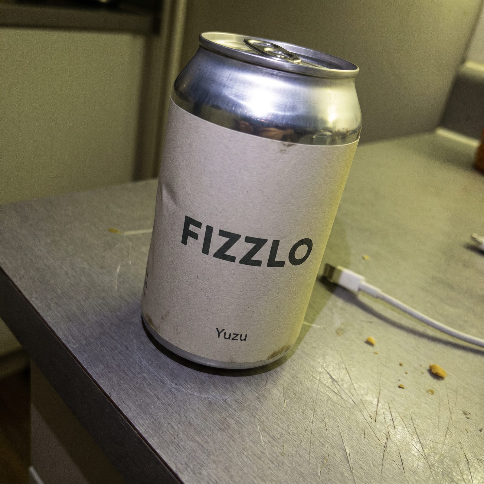 AI-generated before: weak listing-style photo of a FIZZLO Yuzu can